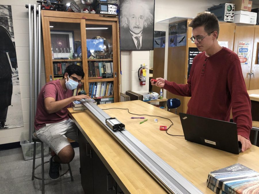 Seniors Vishnu Challa (left) and Nathan Romans (right) doing the Cart on a Ramp lab in AP Physics.
