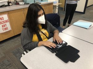 Sophomore Niyati Patel using her BraileSense educational tool to complete her homework for the day.