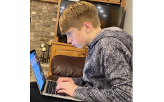 A PV student works on homework while maintaining poor posture.