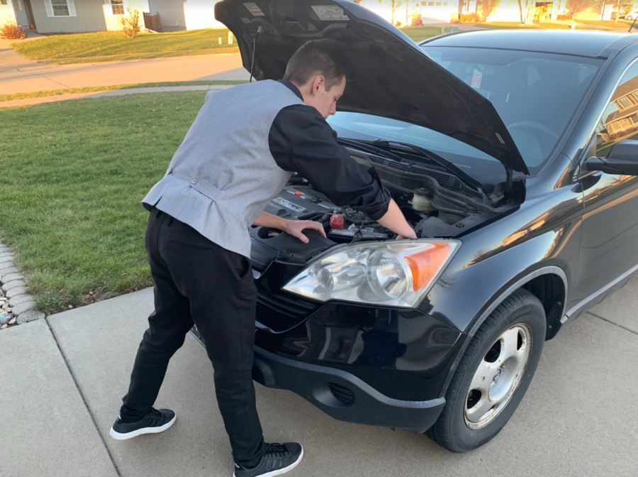 Senior Nathan Romans double-checking his car’s fluids are topped off for the winter.