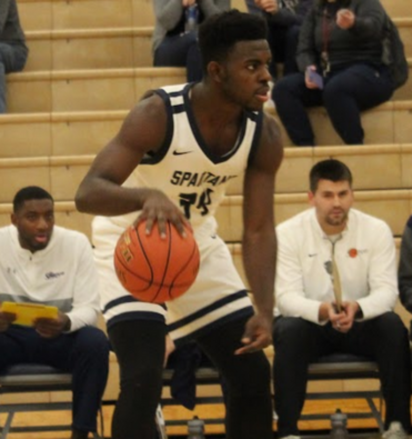 Allan Kamadjeu plays in the boys basketball game against Dubuque Hempstead