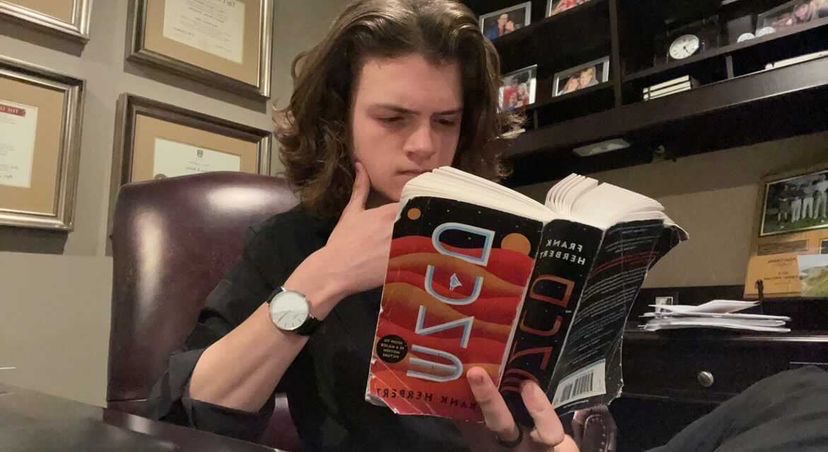 Junior Charles Budan enjoys reading his copy of “Dune.” The original science fiction novel inspired another film adaptation, which will be released in two parts, the first of which hit theaters on Oct. 22, 2021. 