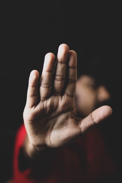 A student holds their hand up as a gesture against sexual assault. 