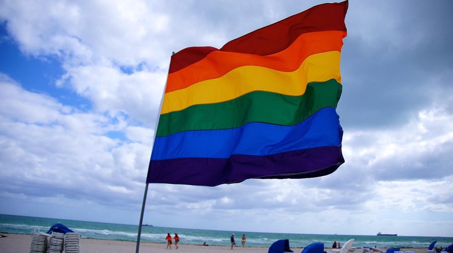 LGBTQ+ pride flag flies on Florida beach.