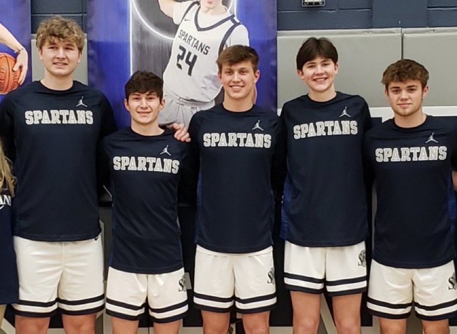 The 2021/2022 Pleasant Valley seniors pose on senior night after beating Muscatine 73-45.