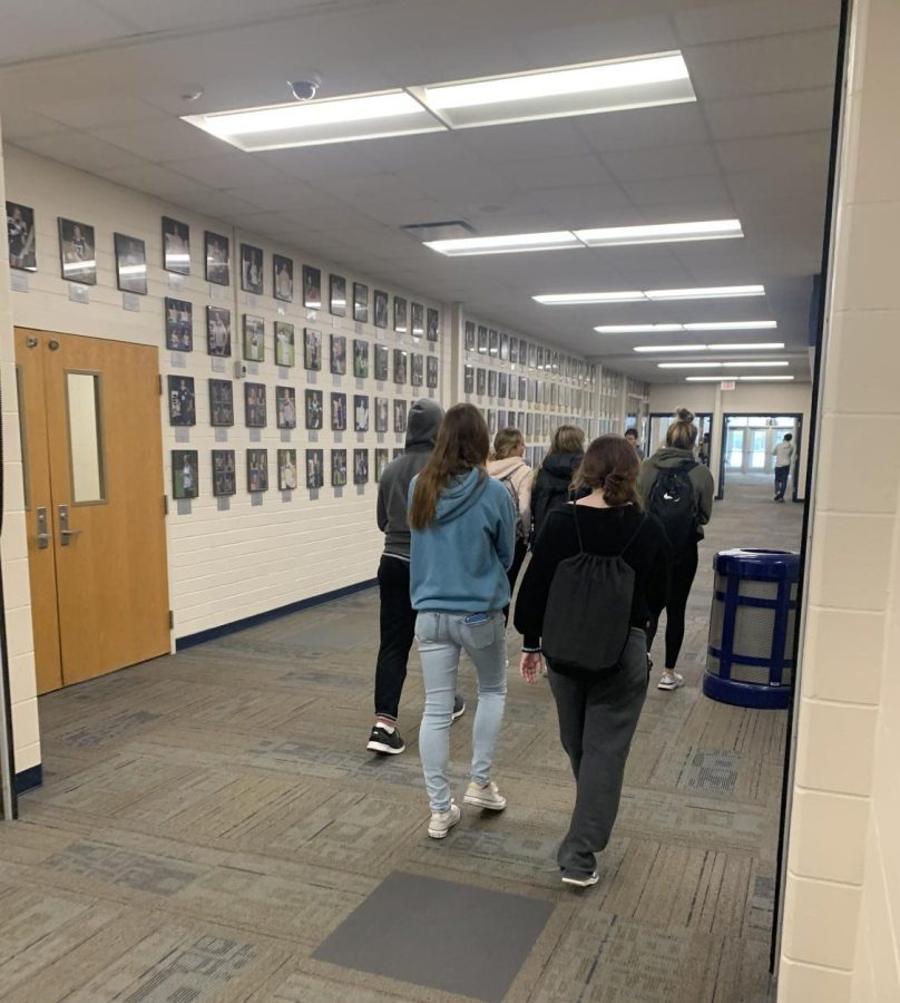 Students walking down a hall adorned with pictures of the school’s most elite athletes.
