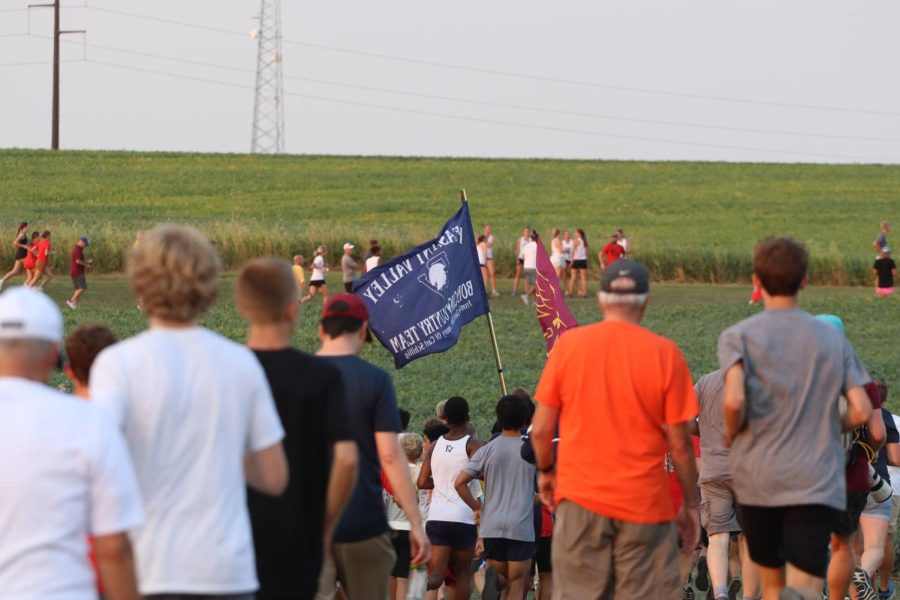 The flag of the PV boys’ cross country team flies high as spectators make their way to the finish of the varsity boys’ race in Marshalltown, Iowa, Thursday, Sept. 9, 2022. 
