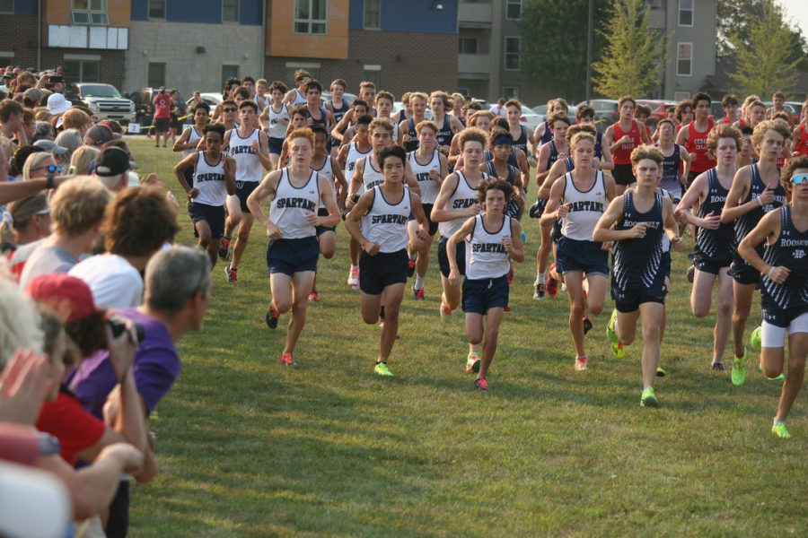 The+Pleasant+Valley+Boys+Cross+Country+Freshman-Sophomore+team+darts+off+the+start+line+together+as+spectators+cheer+on.%0A