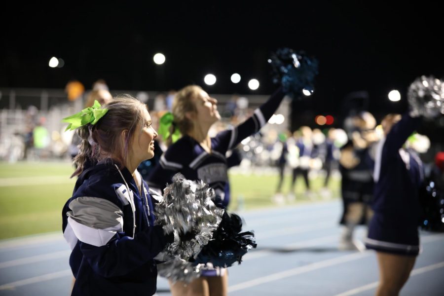 Senior cheerleaders Caity Burke and Caroline Corcoran lead the student section through a series of cheers with the rest of their team. 