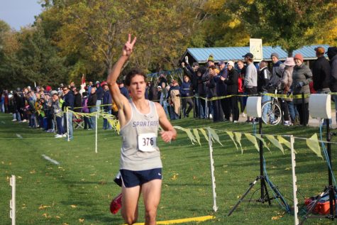 Senior Jacob Mumey holds two on his fingers as he repeats as MAC champion with a time of 15:50 at  Crow Creek Park on Oct. 13, 2022. 