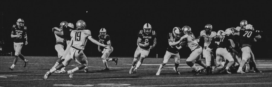 Senior Rusty VanWetzinga (8) of the Pleasant Valley Spartans runs his route through the Iowa City West Trojans defensive line, Oct. 21, 2022. VanWetzinga carried for 93 yards and ran for 3 touchdowns, leading them to a 35-14 win in the final game of the season. 