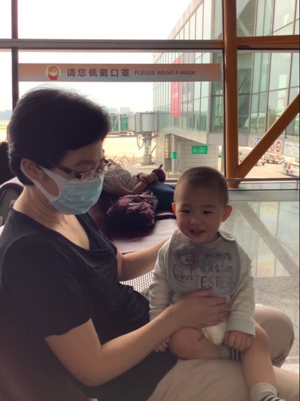 Xiaowen Zhang, a professor at St. Ambrose, sits in the Beijing airport with her son while trying to travel back home to visit her mother. 
