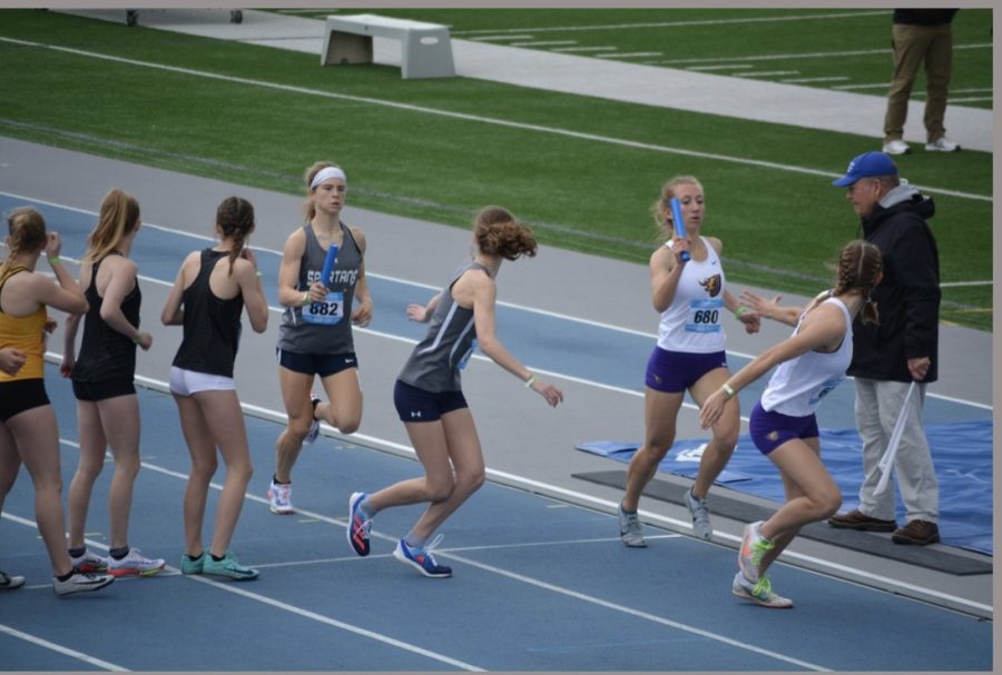 Grace Boleyn handing the baton to Lydia Sommer during the 4x800 meter dash at Drake Relays in 2022.