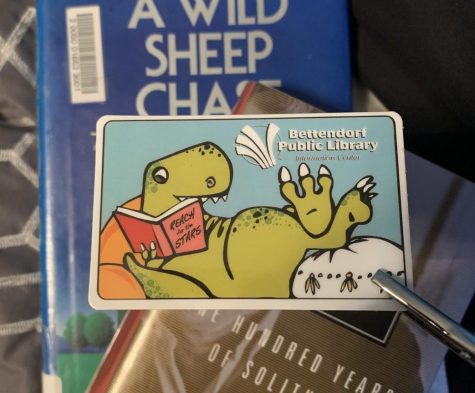 The Bettendorf Public Librarys Dinosaur Library card lies in front of some books as the library recently went fine-free.