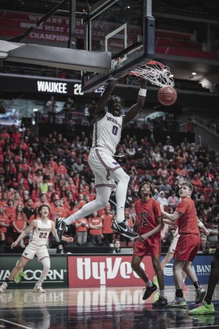 Senior Omaha Biliew (0) of the Waukee Warriors dunks on the Ames Little Cyclones during the 4A state playoffs, March 8, 2023. 