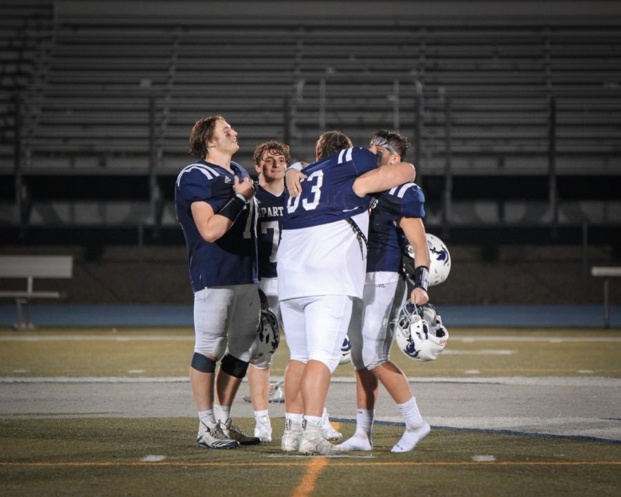 Seniors Tommy Jeffries (76), Rusty VanWetzinga (8), Blayne Farmer (72), and Nate Cox (63) embrace each other on the field after their final games as Pleasant Valley Spartan football players.