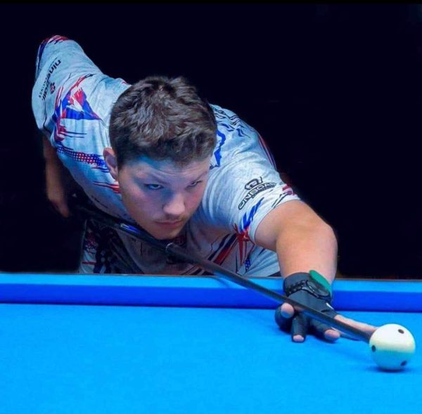 Billiards player, Sam Henderson, lines up for a shot.