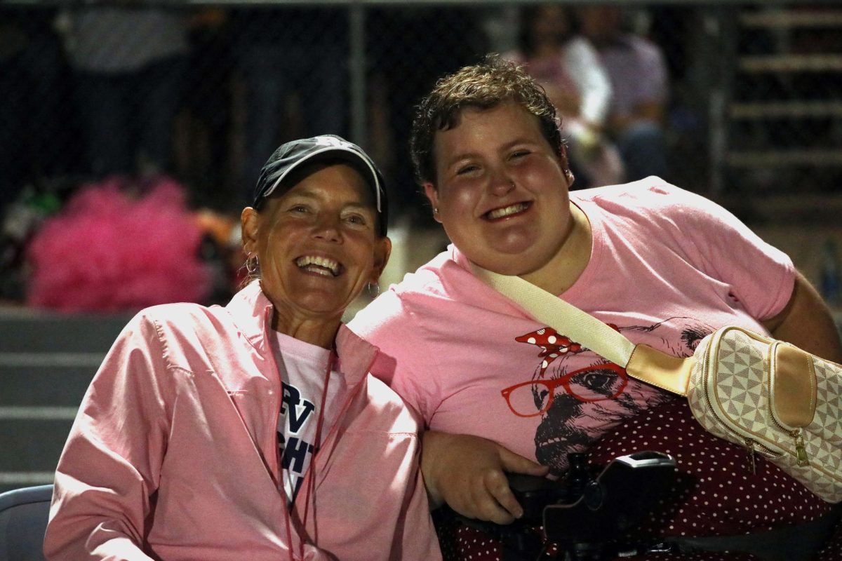 Athletic director DAnne Kroemer takes a moment to smile with senior Lynsey Stevenson under the Friday night lights during a game against Cedar Rapids Prarie on Sept. 15. Kroemer has been the athletic director of Pleasant Valley High School for over a decade.
