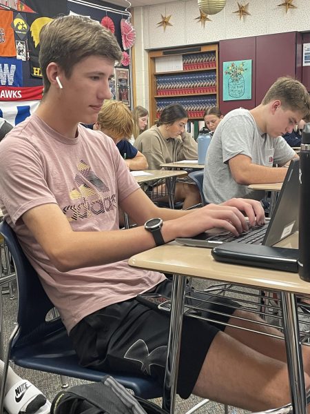 Junior Isaac Neumann listens to music while working on classwork in economics. 
