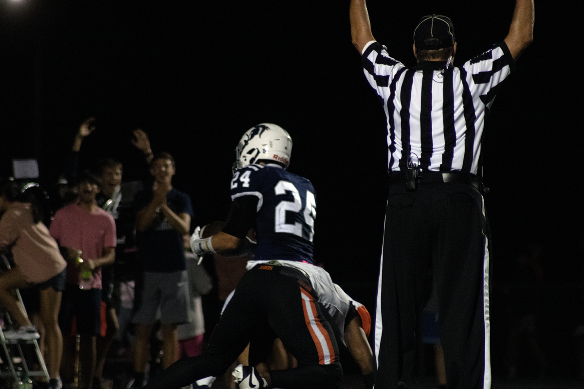 Football Referees make a touchdown call at a home football game. The amount of officiating crews has decreased greatly over the last couple years.  Photo credit to Spartan Shield staff
