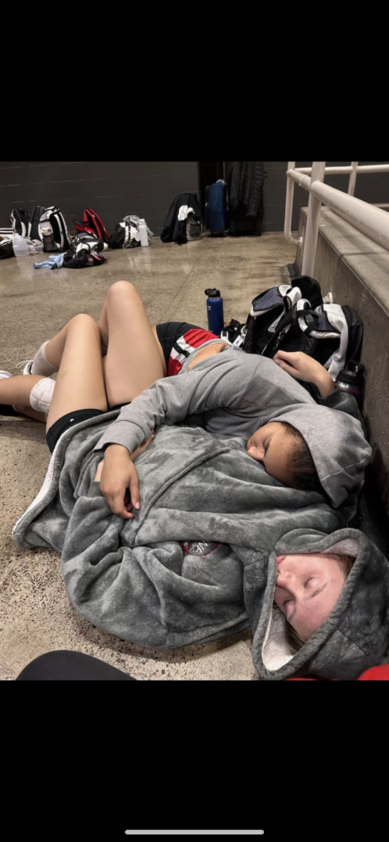 Ellis Hughes (closest) and Gabi Ragins (farthest) sleeping at a national tournament because it was their fourth day of playing at nationals. They were getting some rest before getting back up to play 2 more volleyball games, followed by an eight hour car ride back home while doing schoolwork.
