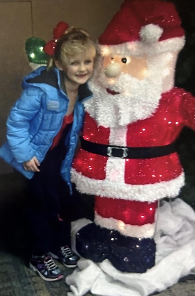 Ava Neitzel posed with a Santa Claus decoration during the 2013 holiday season. Santa is just one of many factors that bring excitement to the season. Photo credit to Ava Neitzel