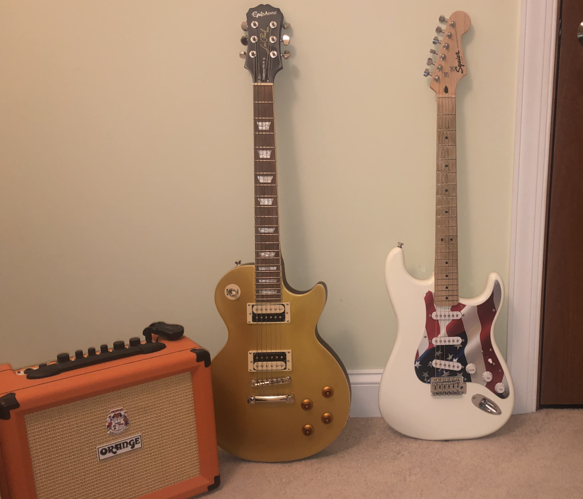 A Les Paul (Left) and modified Stratocaster (Right) sit next to an Orange brand amplifier.