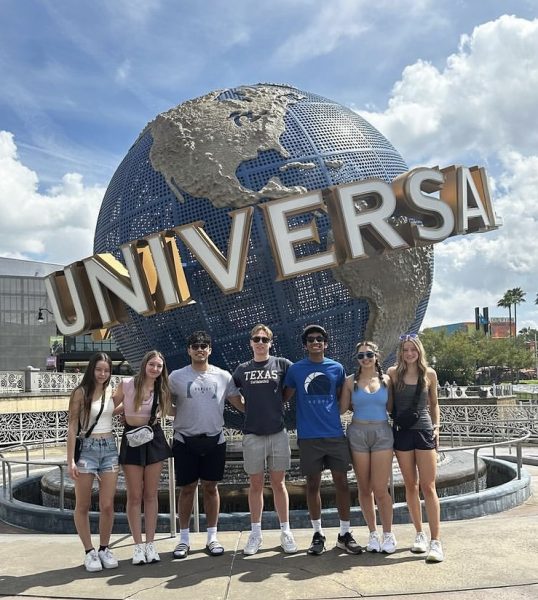 Students pose together in front of the iconic Universal Studios Orlando logo