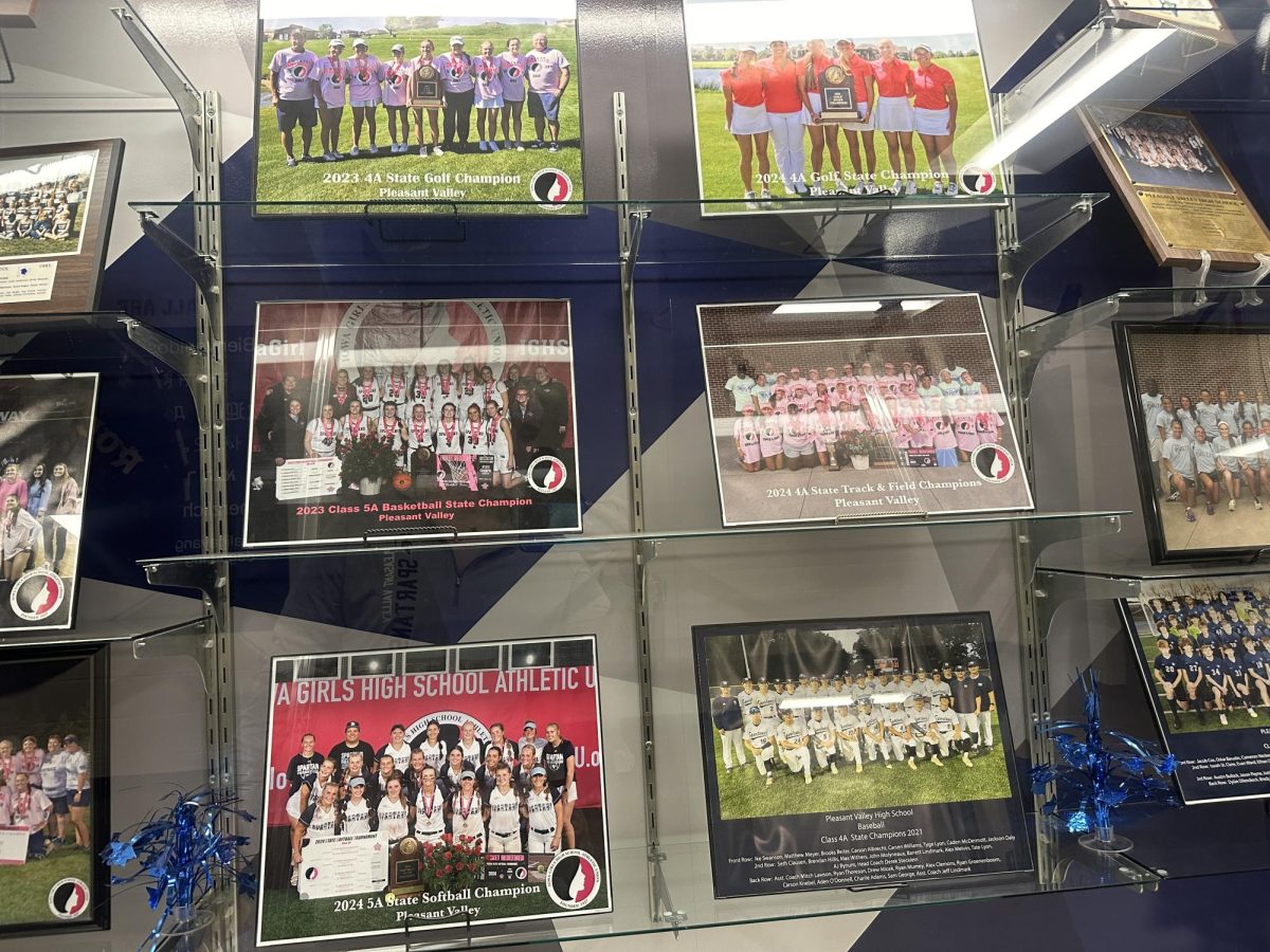 The case of champions displays the portraits of recent Pleasant Valley state championship winning teams. The women's track, softball and golf teams all notched state championship titles during the 2023-2024 school year. 