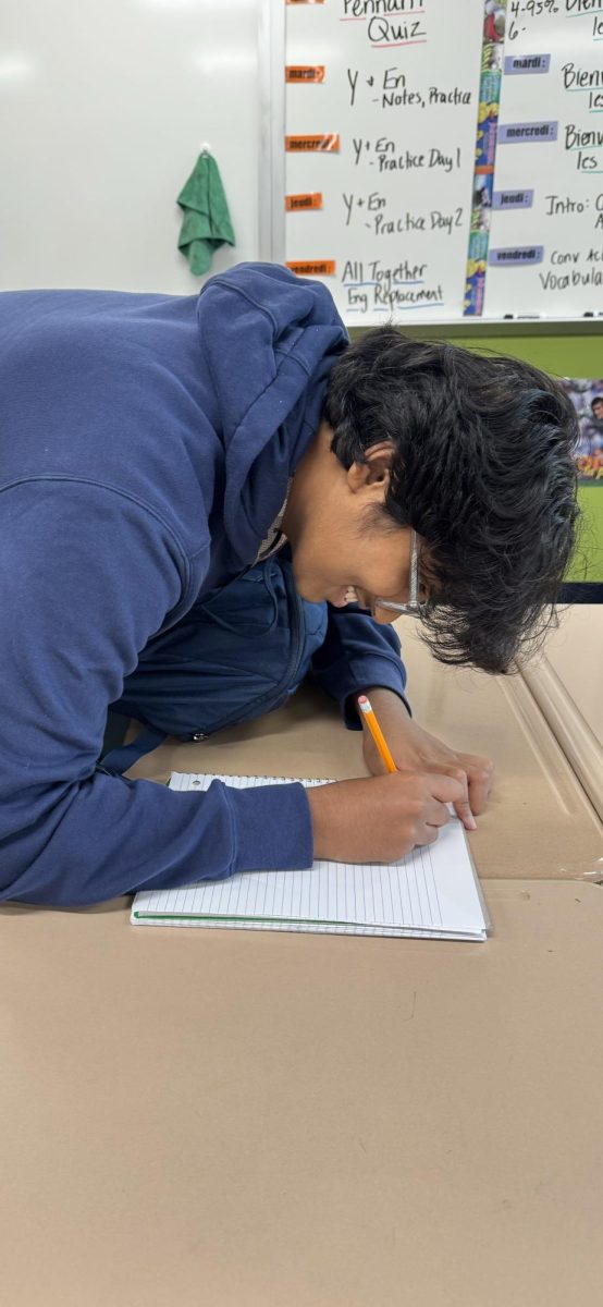 A student is completing his homework in his notebook.