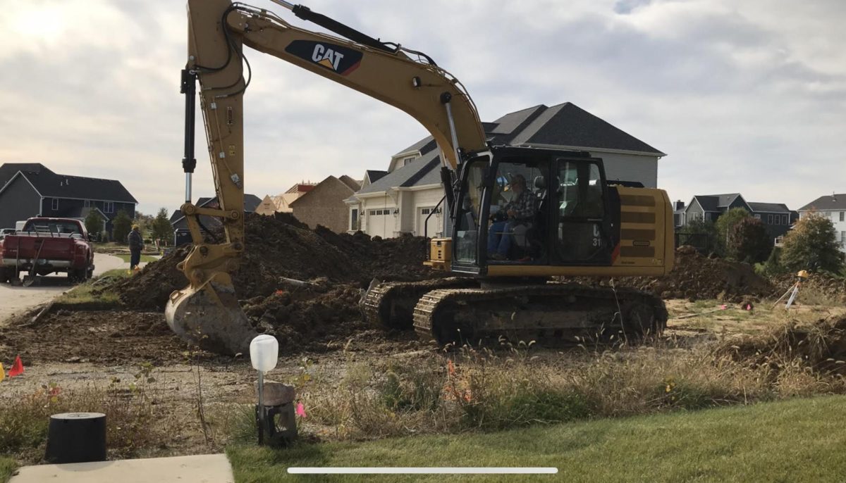 Construction equipment remains idle for months on future housing sites, concealing the greenery and farmland underneath.

