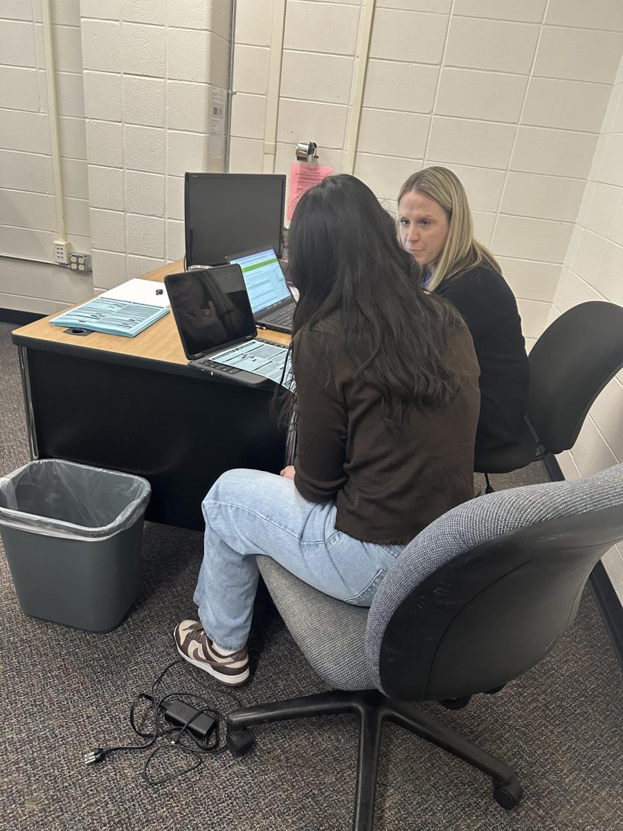 Counselor Nichole Shea helps a student with their class registration for the next school year.