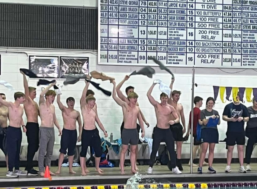 Varsity swimmers spectate the JV Mac meet and cheer on their teammates during the final event of the day.