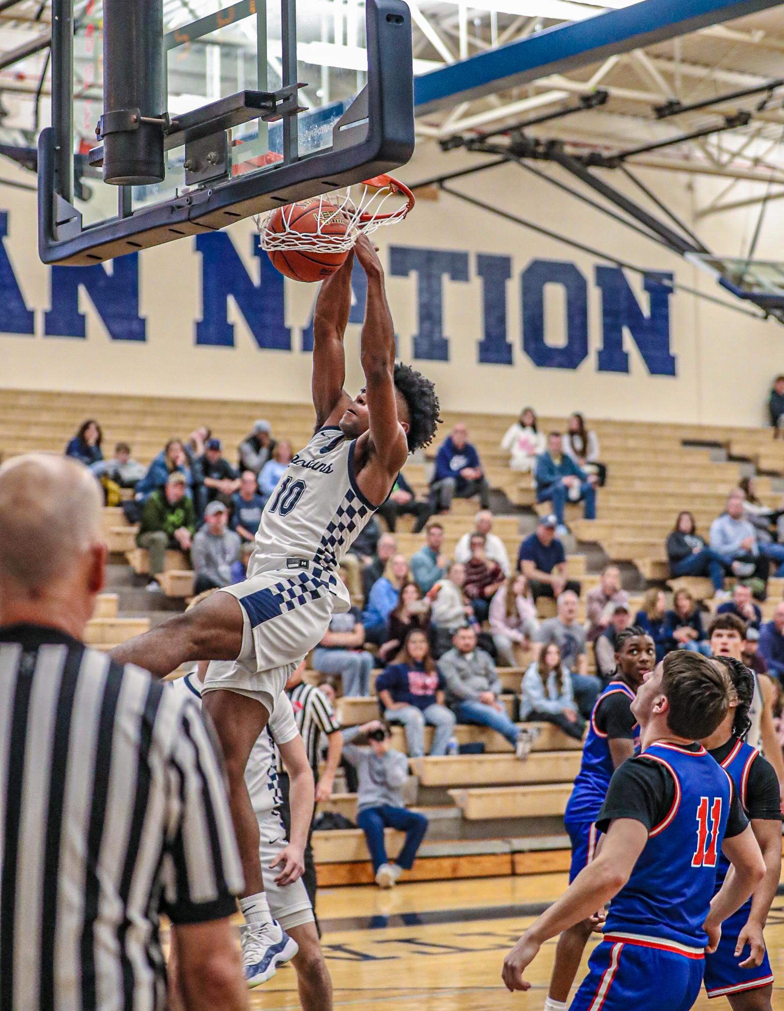 Senior Devin Harper dunks to add two points for the Spartans in their game against the Central Blue Devils. 