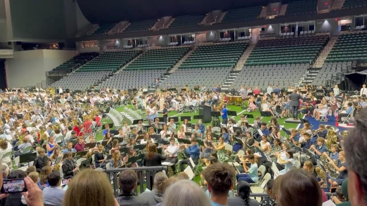 800 Band students preparing for their final performance for the year in the vibrant arena.